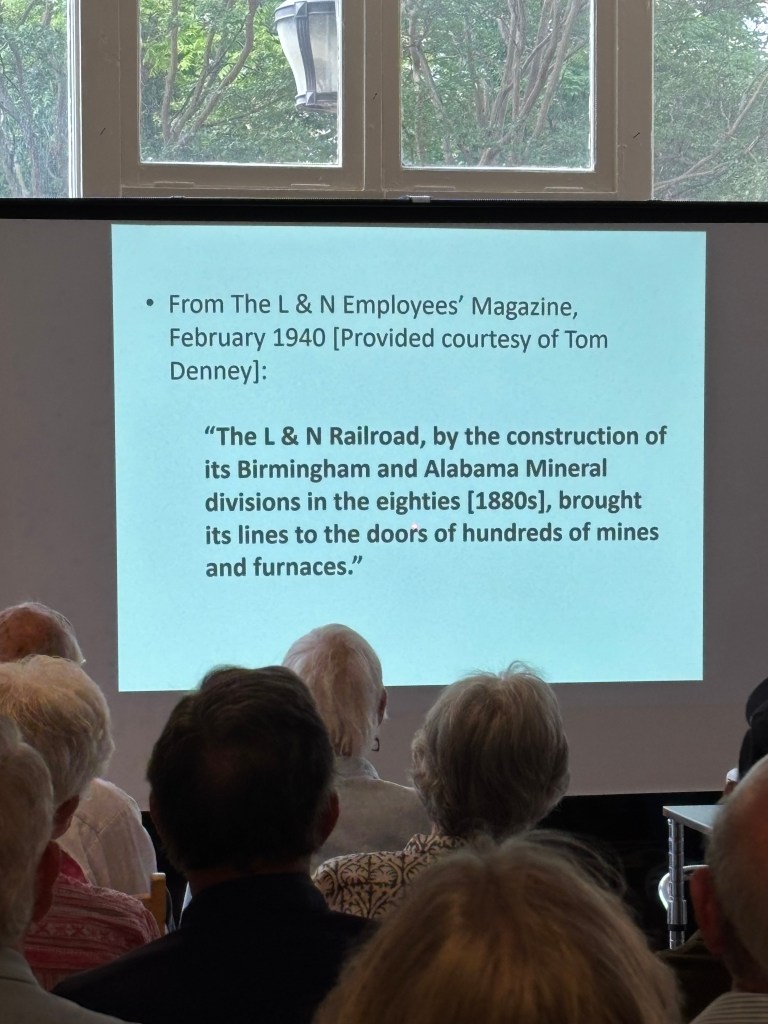 Presentation slide displaying an excerpt from The L & N Employees' Magazine, February 1940, discussing the historical impact of the L & N Railroad on coal mines and furnaces, with a blurred audience in the foreground.